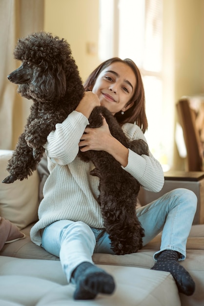 Foto gratuita niña abrazando a su perro mientras está en cuarentena