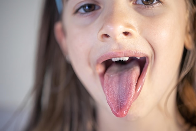 Foto gratuita una niña abre la boca y muestra su lengua.