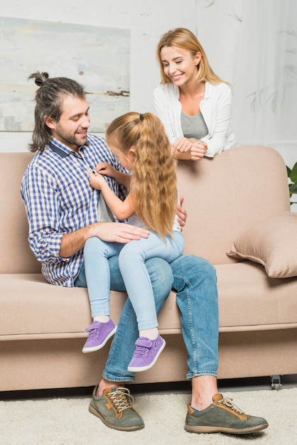 Niña abrochando camisa de su padre