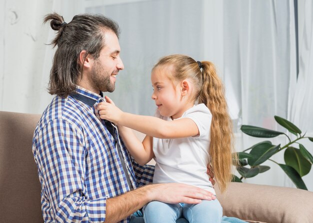 Foto gratuita niña abrochando camisa de su padre