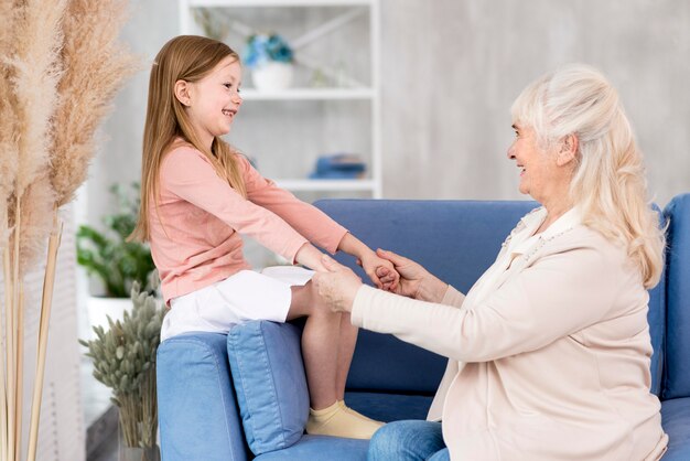 Niña con la abuela sentada en el sofá