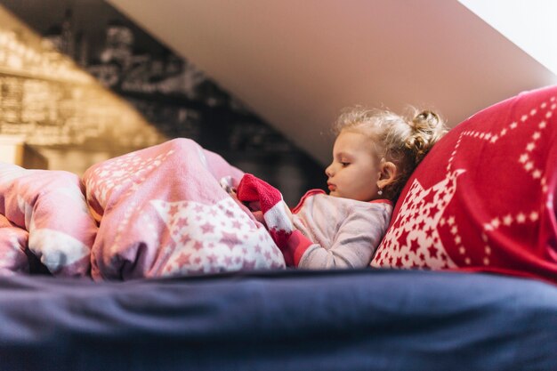 Foto gratuita niña acostada en la cama