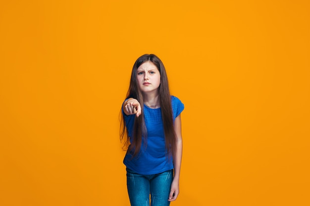 La niña adolescente feliz apuntando a usted, retrato de primer plano de media longitud