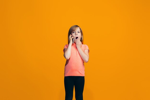 La niña adolescente feliz de pie y sonriente