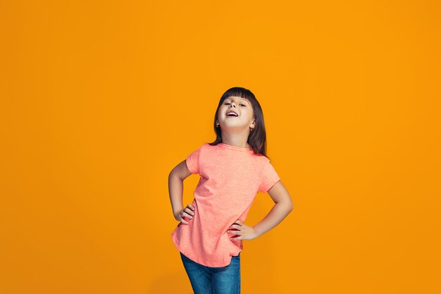 La niña adolescente feliz de pie y sonriente