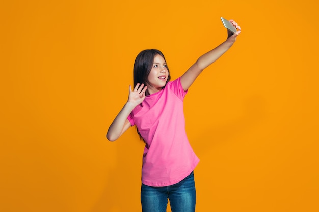 La niña adolescente feliz de pie y sonriente