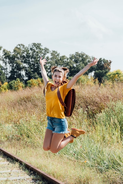 Foto gratuita niña adolescente feliz saltando en el ferrocarril