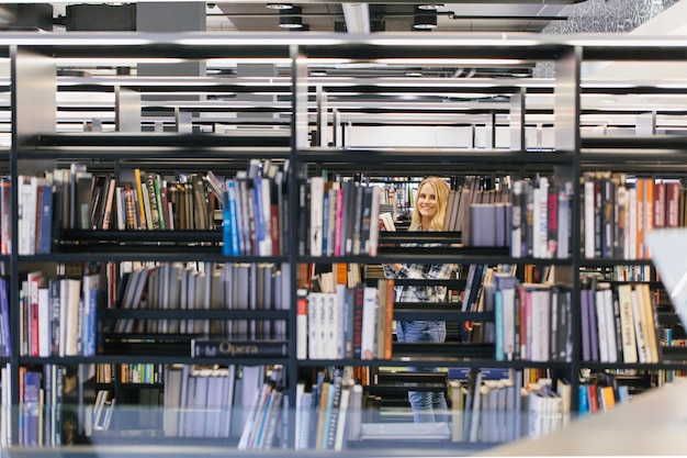 Niña adolescente sonriente en la biblioteca