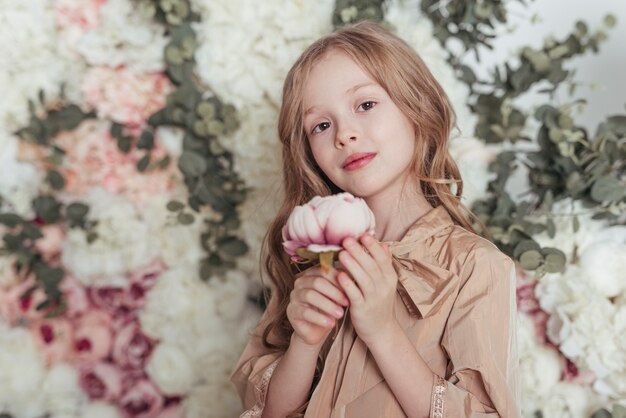 Niña adorable que sostiene la flor