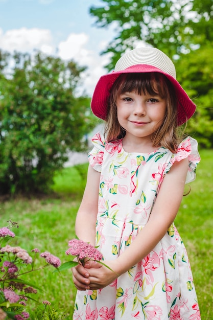 Niña adorable con un ramo de flores silvestres