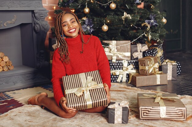 Niña africana en adornos navideños / Mujer con un suéter rojo. Concepto de año nuevo.