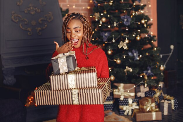 Niña africana en adornos navideños / Mujer con un suéter rojo. Concepto de año nuevo.