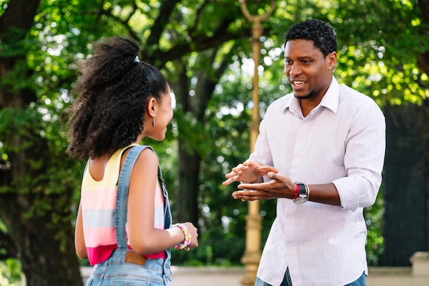 Niña afroamericana con su padre pasar un buen rato juntos al aire libre en la calle
