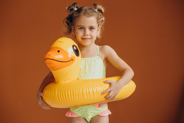 Niña aislada vistiendo traje de baño y tubo de pato de goma