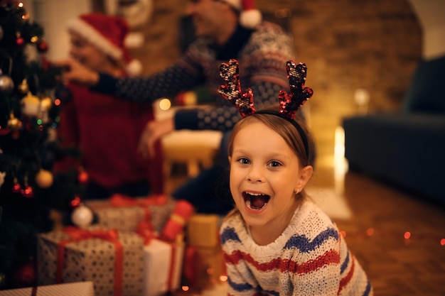 Niña alegre divirtiéndose en la víspera de Navidad en casa