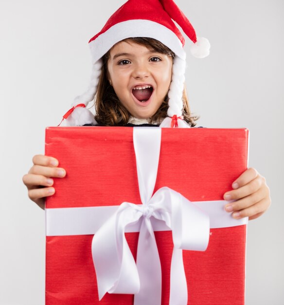 Niña alegre enseñando un regalo