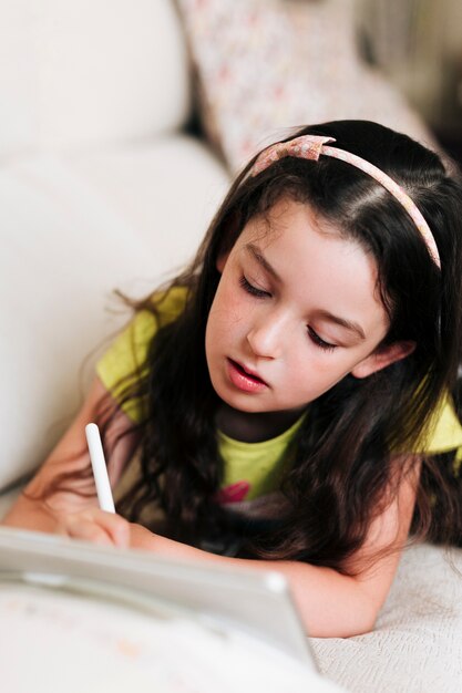 Niña de alto ángulo de dibujo en su tableta