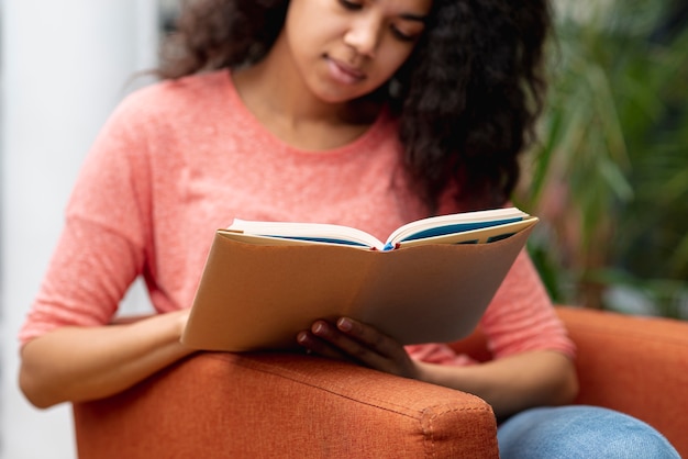 Foto gratuita niña de alto ángulo en lectura de sillón