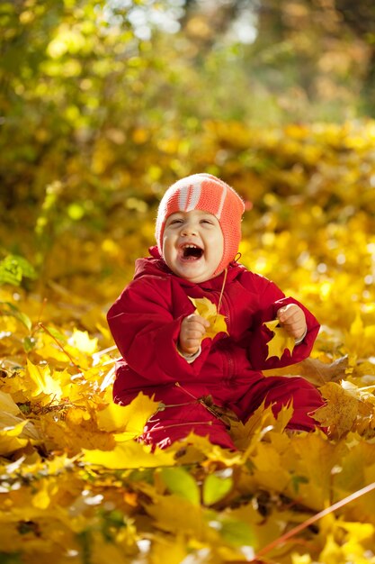 Niña de un año de edad en el parque de otoño