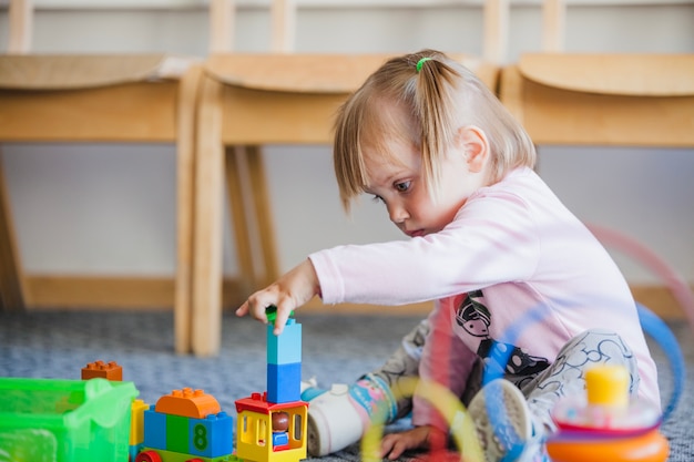 Niña apilando juguetes en la sala de juegos