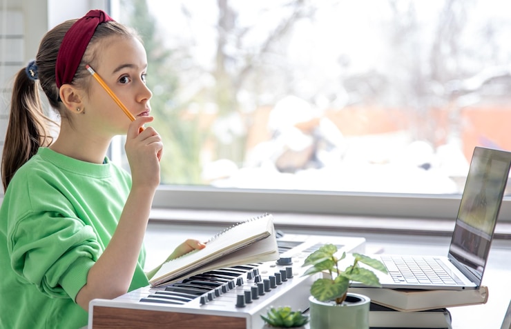 Foto gratuito una niña aprende a tocar el piano con un maestro de música de aprendizaje remoto en línea