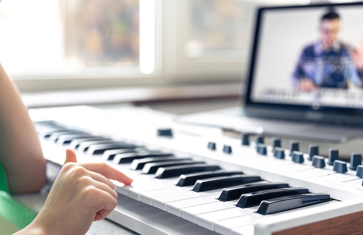 Foto gratuito una niña aprende a tocar el piano con un maestro de música de aprendizaje remoto en línea