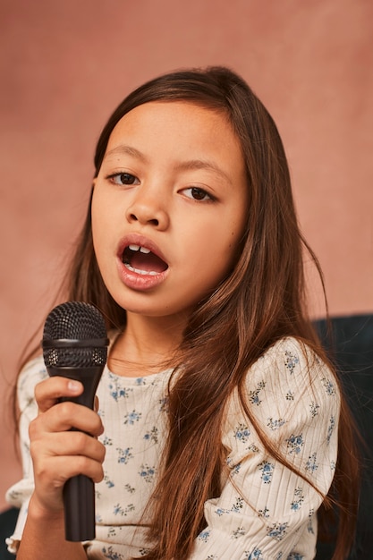 Foto gratuita niña aprendiendo a cantar en casa