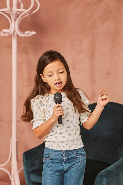 Niña aprendiendo a cantar en casa