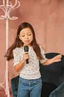 Foto gratuita niña aprendiendo a cantar en casa