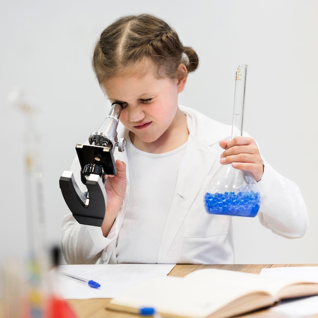 Niña aprendiendo a hacer ciencia con microscopio