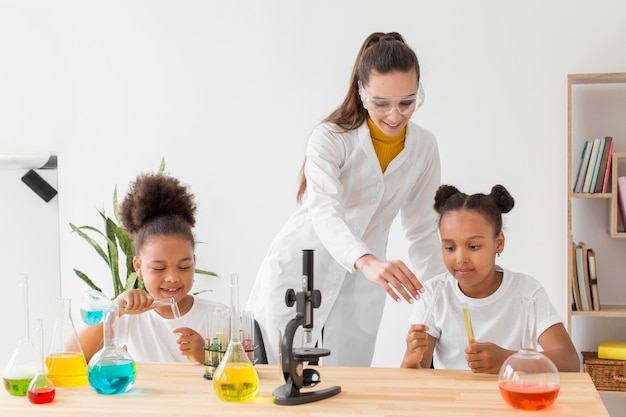 Foto gratuita niña aprendiendo sobre química de una mujer científica