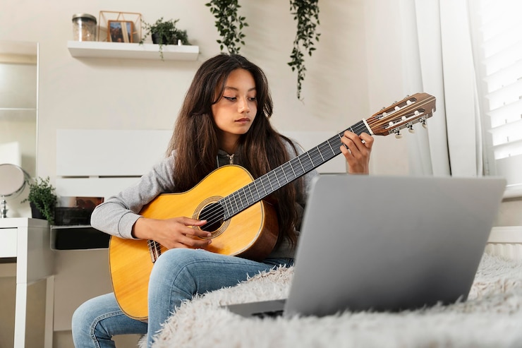 Foto gratuito niña aprendiendo a tocar la guitarra