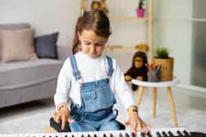 Foto gratuita niña aprendiendo a tocar el piano