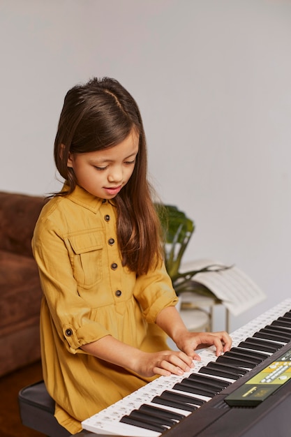 Niña aprendiendo a tocar el teclado electrónico