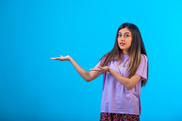 Niña apuntando a algo en azul.