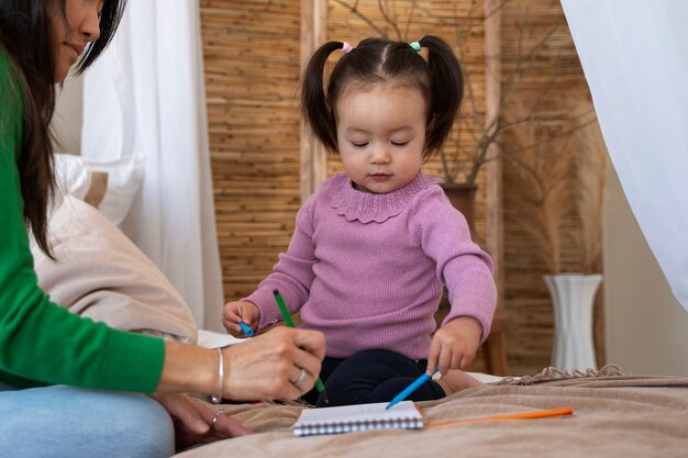 Niña asiática que pasa tiempo en casa con su madre