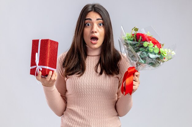 Niña asustada en el día de San Valentín con caja de regalo con ramo aislado sobre fondo blanco.