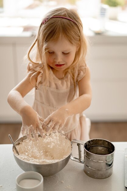 la niña ayuda a mamá en la cocina a cocinar pasteles de Pascua. Familia feliz preparándose para Pascua