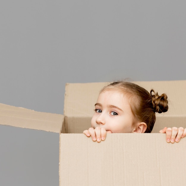 Foto gratuita niña ayudando a empacar las cajas