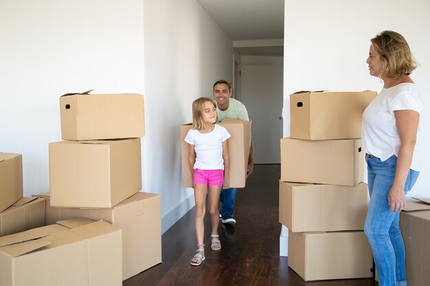 Niña ayudando a los padres a mudarse a un nuevo apartamento