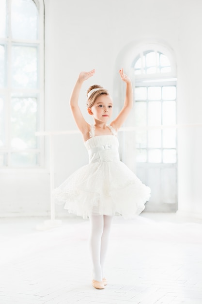 Foto gratuita niña bailarina en un tutú. adorable niño bailando ballet clásico