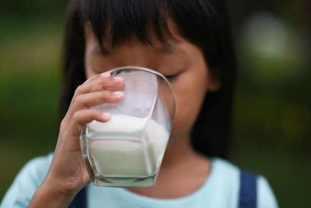 Niña bebiendo leche en el parque