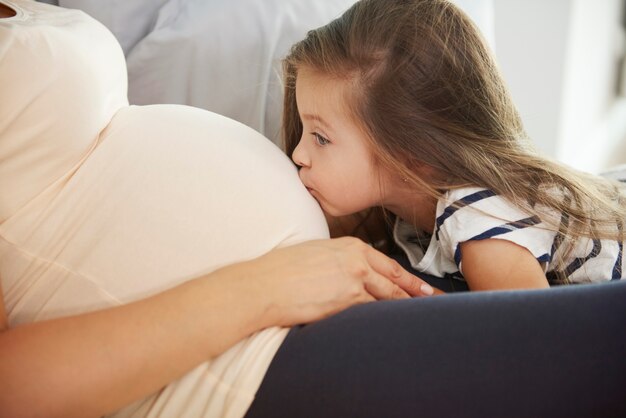 Niña besando a su futuro hermano