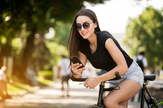 Niña en bicicleta con teléfono