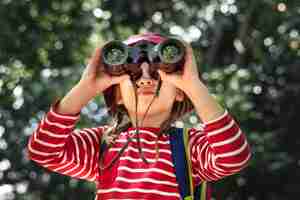 Foto gratuita niña con binoculares en el bosque