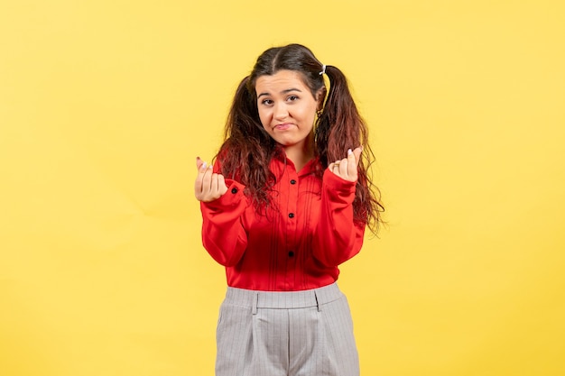 Foto gratuita niña en blusa roja sobre amarillo