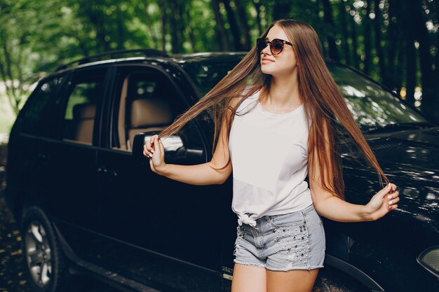 Niña bonita cerca de un coche