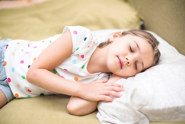 Foto gratuita niña bonita durmiendo en la cama acogedora