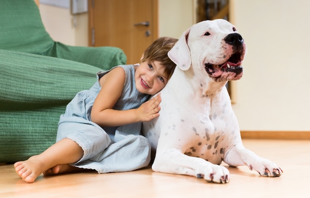 Niña bonita niño en el piso con perro