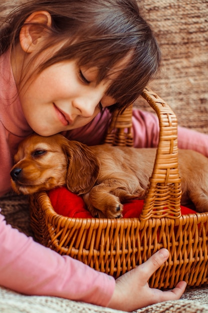 Foto gratuita la niña bonita que se embarca una canasta con perro